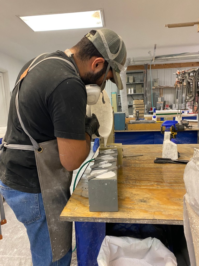 Employee pouring molds for parts in IPI Inc. Headquarters